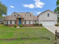 Charming two-story home with a blue front door and well-maintained lawn at 1901 Lakeshore Cir, Longwood, FL 32750