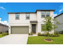 Charming two-story home featuring a manicured lawn, two-car garage, and welcoming front entrance at 2170 Derwent Dr, Davenport, FL 33896