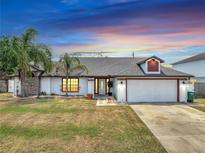 Charming single-story home featuring a well-manicured lawn, two-car garage, and inviting front entrance at 2317 Clearwater Dr, Deltona, FL 32738