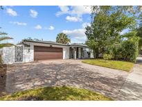 Charming single-story home with an expansive brick driveway and manicured landscaping at 2602 Winter Park Rd, Winter Park, FL 32789