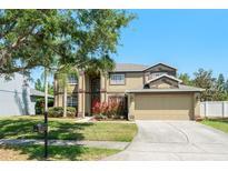 Well-maintained two-story home featuring a two-car garage, mature trees, and landscaped front yard at 2644 Slagrove Ct, Winter Garden, FL 34787