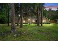 Charming brick home surrounded by mature trees and lush landscaping at 324 Old Mill Rd, Enterprise, FL 32725