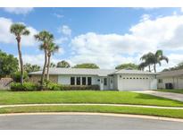 Charming single-story home featuring a well-manicured lawn, palm trees, and a two-car garage at 3317 Dormer Ct, Winter Park, FL 32792