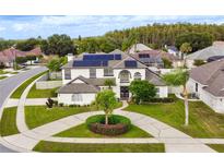 Stunning two-story home with solar panels and a circular driveway surrounded by well-maintained landscaping at 3532 Amaca Cir, Orlando, FL 32837