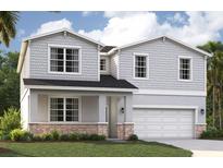 Charming two-story home with gray siding, stone accents, and a well-manicured lawn at 3565 Dahlia Dr, Lake Hamilton, FL 33851