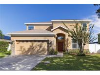 Inviting home with a two-car garage, warm colors, and stone veneer accents at 3680 Ricky Ln, St Cloud, FL 34772