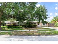 Single story brick home with well maintained landscaping and a large shade tree in the front yard at 4021 Hargill Dr, Orlando, FL 32806