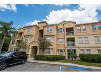 Multi-story condo with a peach facade and parking at 419 Terrace Ridge Cir # 419, Davenport, FL 33896