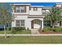 Charming two-story townhouse featuring a well-manicured lawn and a welcoming arched entryway at 4918 Windermere Ave, Kissimmee, FL 34746