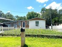 Charming single-story home features a white picket fence and well-maintained front yard at 5050 Howison Rd, Kissimmee, FL 34746