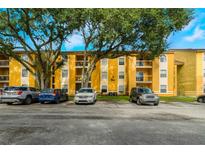 Inviting apartment building with mature trees and well-maintained grounds and convenient parking at 5283 Images Cir # 308, Kissimmee, FL 34746