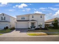 Charming two-story home with a well-maintained lawn, attached two-car garage, and covered entryway at 555 Meadow Bend Dr, Davenport, FL 33837