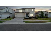 A beautiful two-story home with an attached garage, neat landscaping, and a welcoming entrance at 555 Meadow Bend Dr, Davenport, FL 33837