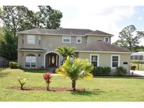 Charming two-story home with lush landscaping and a well-manicured lawn at 7508 Lake Marsha Dr, Orlando, FL 32819
