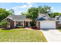 Charming single-story home features a brick accent, manicured lawn, and an attached two-car garage at 8004 Village Green Rd, Orlando, FL 32818