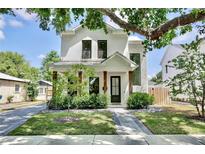 Stunning two-story home featuring a beautifully landscaped front yard and a charming covered entry at 833 Dartmouth St, Orlando, FL 32804