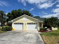 Charming home featuring a well-maintained two-car garage and lovely landscaping at 8829 Courtyard Ln, Groveland, FL 34736
