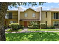 Inviting townhouse with a well-maintained lawn, garden, and walkway leading to a covered front entrance at 1020 Grove St # 29, Maitland, FL 32751