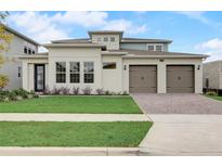 Inviting exterior of a modern two-story home with a manicured lawn and a three-car garage at 18964 Rawson St, Orlando, FL 32827