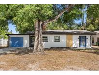 Charming single-story home with a blue garage door and mature trees, offering a welcoming curb appeal at 2014 10Th Nw St, Winter Haven, FL 33881