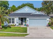 Charming single-story home with a well-manicured lawn, lovely landscaping, and an attached two-car garage at 2098 Carpathian Dr, Apopka, FL 32712