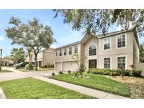 Traditional home featuring a manicured lawn, a two-car garage, and a neutral color palette at 2658 Palmetto Ridge Cir, Apopka, FL 32712