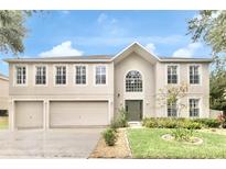 Stunning two-story home with a three-car garage, manicured lawn and beautiful front yard landscaping at 2658 Palmetto Ridge Cir, Apopka, FL 32712