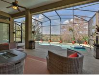 Enclosed pool area featuring stylish wicker furniture and beautiful backyard views at 27127 Stoney Brook Dr, Leesburg, FL 34748