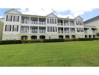 Elegant condo building featuring multiple balconies and a well-manicured lawn at 280 Celebration Blvd # 208, Kissimmee, FL 34747