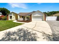 Charming single-story home with a well-manicured lawn, driveway, and two-car garage at 4993 Heatherstone Pl, Orlando, FL 32812