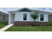 Charming single-story home with stone accents, white trim, and lush green lawn at 5258 Scrub Mint, Apopka, FL 32712