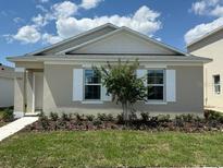 Charming single-story home featuring a well-manicured lawn and beautiful landscaping at 5282 Scrub Mint Ln, Apopka, FL 32712