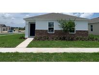 Charming single-Gathering home featuring stone accents, a well-manicured lawn, and a neatly landscaped front yard at 5290 Scrub Mint Ln, Apopka, FL 32712