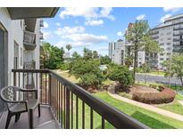 Relax on the balcony overlooking lush grounds, pool, and city skyline at 6165 Carrier Dr # 1304, Orlando, FL 32819