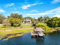Expansive lakefront estate with a boat dock and modern architecture nestled among lush greenery at 705 N Lake Sybelia Dr, Maitland, FL 32751