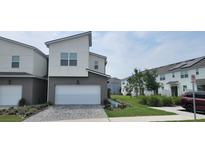 Modern townhome with a two-car garage and stylish gray and white exterior in a well-maintained community at 741 Spring Palms Loop, Orlando, FL 32828