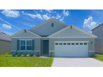 Charming single-Gathering home with a two-car garage, lush lawn, and beautifully landscaped front yard at 939 Princess Sabal Pt, Haines City, FL 33844