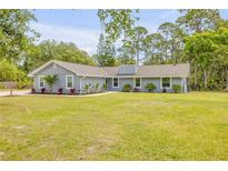 Charming single-story home with a well-manicured lawn, tidy landscaping, and a freshly painted exterior at 106 Pine Tree Dr, Ormond Beach, FL 32174
