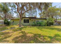 Charming single-story home with a well-maintained lawn and mature trees at 1108 Gibson St, Leesburg, FL 34748