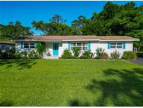 Charming single story home with a well-maintained lawn, bright blue door and shutters, and manicured landscaping at 1118 Ne 17Th Ave, Ocala, FL 34470