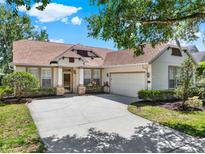 Charming single Gathering home with a well-manicured lawn, beautiful flowers, and a two-car garage at 112 Overton Gardens Lane, Deland, FL 32724