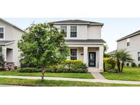 Charming two-story home features a well-manicured lawn and colorful landscaping at 11386 Biography Way, Orlando, FL 32832