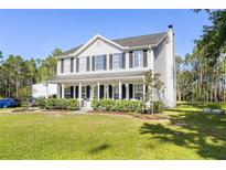 Charming two-story home with a spacious front porch and well-maintained landscaping at 1555 Seminole Run Rd, Osteen, FL 32764