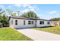 Charming single-story home featuring a white exterior, brick driveway, and well-maintained lawn at 2105 9Th Ne St, Winter Haven, FL 33880