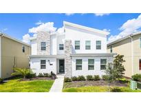 Contemporary two-story home with modern design, stone accents, and a well-maintained front yard at 2916 Simile St, Kissimmee, FL 34746