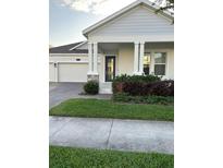 Charming home featuring a two-car garage, stone accents, and well-maintained landscaping at 3084 Ella Way, St Cloud, FL 34771