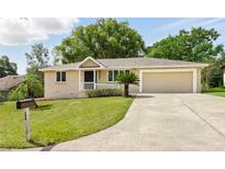 Beautiful single-story home with mature landscaping, a well-manicured lawn, and an inviting driveway at 326 Evergreen Ct, Apopka, FL 32712