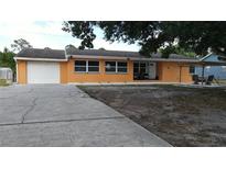 Charming one-story home featuring an attached garage, neutral paint, and a spacious front yard at 3713 N Econlockhatchee Trl, Orlando, FL 32817