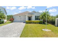 Charming one-story home featuring a well-manicured lawn, a paver driveway, and an attached two-car garage at 4599 Storytelling Way, Kissimmee, FL 34746