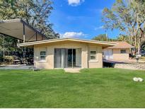 View of backyard with verdant lawn and sliding glass doors and covered parking at 530 Webster St, Lake Mary, FL 32746
